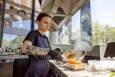 Yetenekli ve kendini işine adamış bir şef, canlı bir mutfak ortamında lezzetli ve lezzetli bir yemek yapmaya odaklanır.