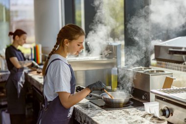 Canlı ve çağdaş bir mutfakta genç bir şef ustalıkla ve tutkuyla lezzetli bir yemek hazırlar.
