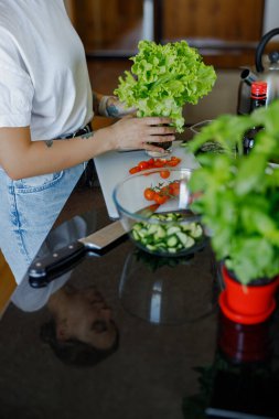 Bir insan modern bir mutfakta taze sebzeler hazırlıyor, sağlığa odaklı sağlıklı bir yemek hazırlıyor.