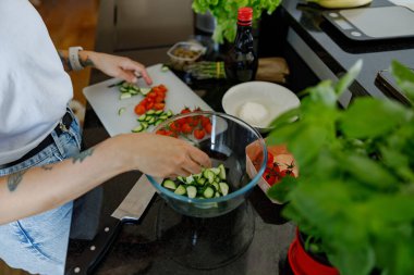 Canlı bir mutfak sahnesi salatalar için taze ve renkli sebzelerin hazırlanmasını güzel bir şekilde gözler önüne seriyor.