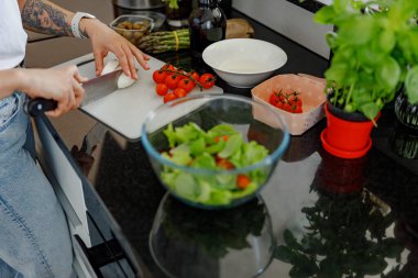 Şık bir mutfak ortamında taze sebzeler kullanarak enfes ve sağlıklı bir salata hazırlıyorum.