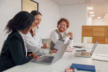 Çeşitli profesyonellerden oluşan bir grup, yaratıcı ve işbirlikçi bir ofiste stratejileri ve yenilikçi fikirleri tartışıyor.