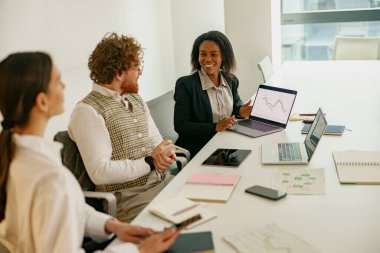 Dinamik bir ekip yenilikçi stratejileri modern ofis ortamında gelişmiş dijital araçlarla tartışıyor