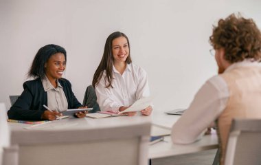 Çeşitli katılımcılarla bir takım toplantısı modern bir çalışma alanında anahtar fikirleri tartışır.