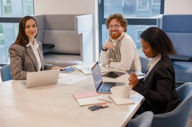 Dinamik ve çeşitli bir ekip şık ve modern ofis ortamında heyecan verici bir proje üzerinde aktif olarak işbirliği yapıyor.