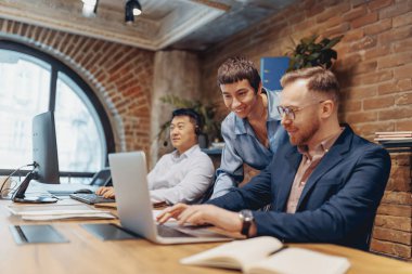 Dinamik takım çalışması, güzel bir şekilde işbirliği, yaratıcılık ve teknolojiyi gösteren şık bir çalışma alanında gelişir.