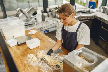 Yetenekli bir şef enfes bir makarna yapıyor, canlı ve lezzetli bir mutfakta mutfak sanatını sergiliyor.