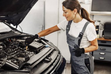 Çok yetenekli bir tamirci modern otomotiv atölyesinde motoru dikkatle inceler.