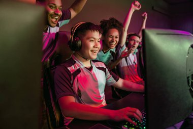 Oyunculardan oluşan canlı bir grup, takım çalışması ile heyecan verici bir esportta zorlu bir zaferi kutluyor.