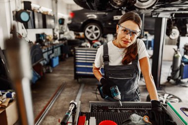 Yetenekli bir tamirci, uzmanlığını ve aletlerini yoğun bir garajda sergiliyor. Tamir becerilerini ve adanmışlığını vurguluyor.
