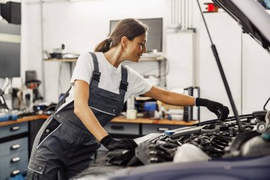 Çok yetenekli bir tamirci, araba bakımı konusunda uzmanlık sergileyen bir motor üzerinde özenle çalışıyor.