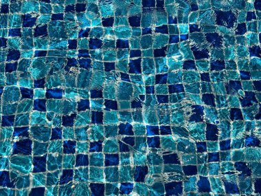 Arka plan olarak suyun içinde yüzme havuzunun seramik mozaiği.