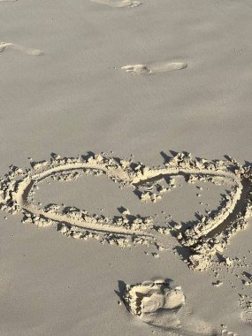 Yaz tatilinde kumlu bir sahil, aşkın sembolü..