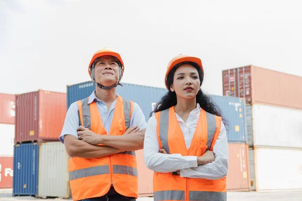 Female Asian engineer and foreman engineer loading containers from cargo ship for export. There is a container in the background.