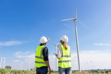 Rüzgar türbini çiftliğinde çalışan mühendis ekibi. Alternatif enerji kavramına göre rüzgar jeneratörüyle yenilenebilir enerji.