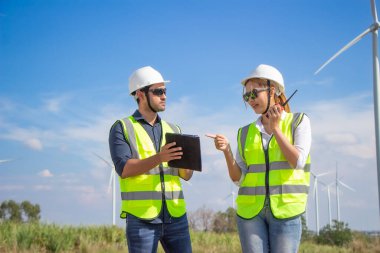 Rüzgar türbini çiftliğinde çalışan mühendis ekibi. Alternatif enerji kavramına göre rüzgar jeneratörüyle yenilenebilir enerji.