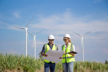 Rüzgar türbini çiftliğinde çalışan mühendis ekibi. Alternatif enerji kavramına göre rüzgar jeneratörüyle yenilenebilir enerji.