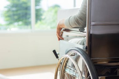 Kafkasyalı erkek doktor, tekerlekli sandalyedeki yaşlı kadın hastayı muayene ediyor..