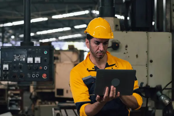 Caucasian engineer using a laptop in a factory. man working in  factory.