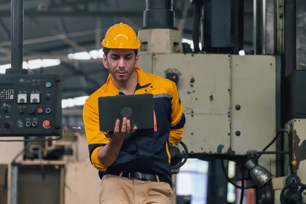 Caucasian engineer using a laptop in a factory. man working in  factory.