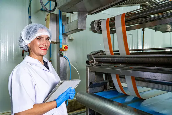 caucasion woman working in a food factory wearing protective clothes and gloves