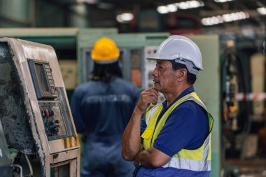 Eski fabrikada kapalı alanda sanayi işçisi. Sert Şapkalı Endüstriyel Mühendisler. Ağır Sanayi Üretim Fabrikasında çalışıyorlar..