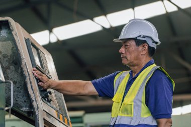 Eski fabrikada kapalı alanda sanayi işçisi. Sert Şapkalı Endüstriyel Mühendisler. Ağır Sanayi Üretim Fabrikasında çalışıyorlar..