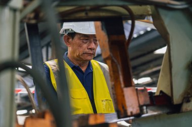 Eski fabrikada kapalı alanda sanayi işçisi. Sert Şapkalı Endüstriyel Mühendisler. Ağır Sanayi Üretim Fabrikasında çalışıyorlar..