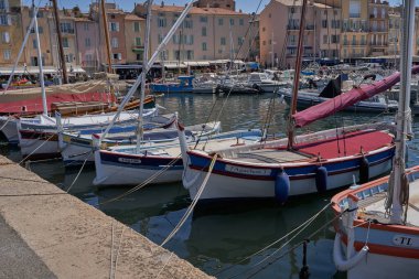  Saint-Tropez, Fransa - 8 Ağustos 2022 - Lüks yatlar, botlar ve yelkenliler eski kasaba bölgesindeki liman marinası, dükkanlar ve kafeler arasında yer alıyorlar.                               