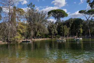 Roma, İtalya - 22 Eylül 2022 - Ziyaretçiler Villa Borghese bahçesindeki gölde kürek çekiyorlar.                               