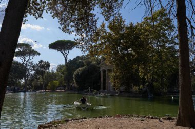 Roma, İtalya - 22 Eylül 2022 - Ziyaretçiler Villa Borghese bahçesindeki gölde kürek çekiyorlar.                               