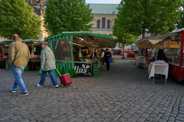Muenster, Almanya - 3 Mayıs 2025 - İnsanlar katedral meydanındaki haftalık çiftçi pazarında sabahın erken saatlerinde                               
