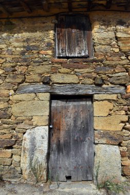Taş bir evde eski bir pencere ve kapı. Puebla de Sanabria 'da. Zamora. İspanya