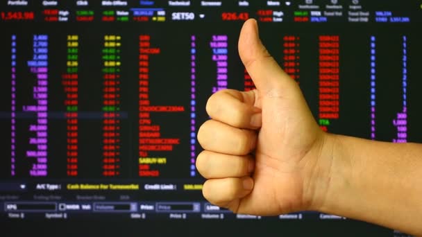 男は株式交換ボードの背景と親指を表示しています スタジオでチェンマイタイ — ストック動画