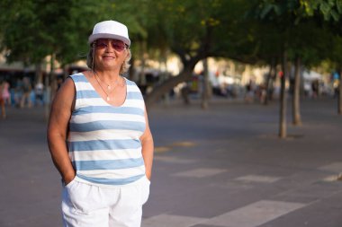 Çizgili gömlekli ve beyaz şortlu bir kadın.