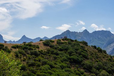 Yeşil Çayırdaki Bulutların Arasındaki Yüksek Dağlar: Görkemli Manzara