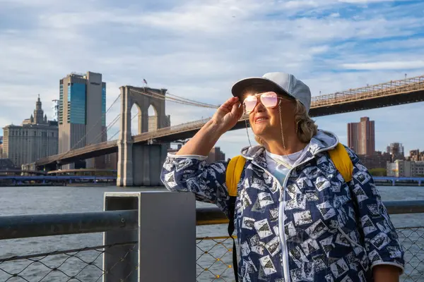 見事なマンハッタンビューでニューヨークを横断する高齢女性 — ストック写真