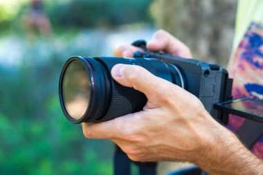 Elinde kamerayla anları yakalayan bir adam.