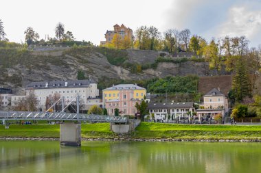 Nehir üzerindeki köprüde güzel bir manzara, eski Avrupa kenti, Salzburg 'un dağ manzarası; Avusturya, Salzburg, 28 Ekim 2022.