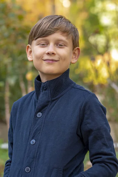 自然を背景にした幸せな10歳の少年のストリートポートレート — ストック写真