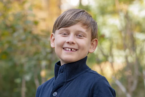 Pouliční Portrét Usměvavého Desetiletého Chlapce Rozmazaném Pozadí Přírody Chybí Jeden — Stock fotografie