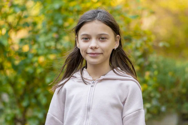 Portrait of cute twelve year old girl in the park. Stock Photo