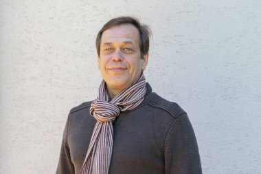 45-50 yaş arası mutlu bir adamın portresi. Kazak ve fular içinde..