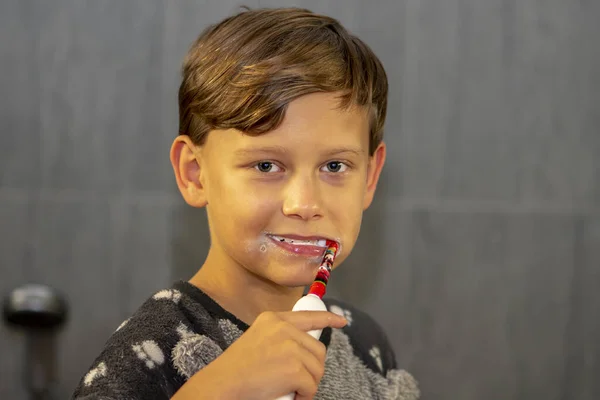 Veselý Desetiletý Chlapec Čistí Zuby Elektrickým Kartáčkem Zuby Koupelně — Stock fotografie