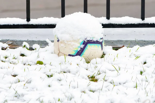 Μπάλα Ενός Παιδιού Είναι Ξαπλωμένη Στο Γρασίδι Καλυμμένη Πρώτο Χιόνι — Φωτογραφία Αρχείου