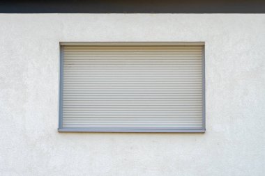 The window in the house is closed with white shutters. clipart