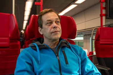 45-50 yaşlarında düşünceli bir adam tren vagonunda..