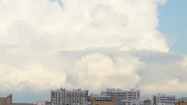 随着时间的流逝 白色的积云迅速地漂浮在城市建筑物的屋顶上 — 图库视频影像