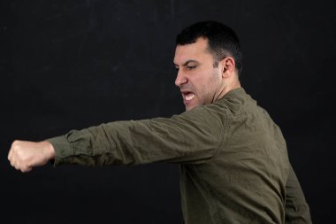 30-35 yaşlarında siyah saçlı bir adam grev yapıyor..