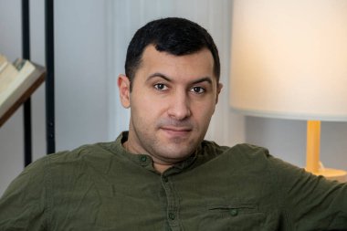 30-35 yaşlarındaki bir adamın portresi kitaplarla ve lambalarla dolu bir rafın arka planında 30-35 yaşlarındaki bir adamın portresi..